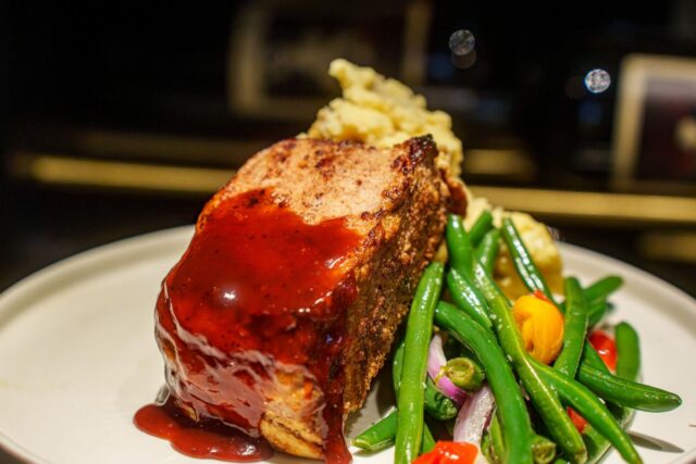 Bacon-wrapped meatloaf with mashed potatoes and green beans