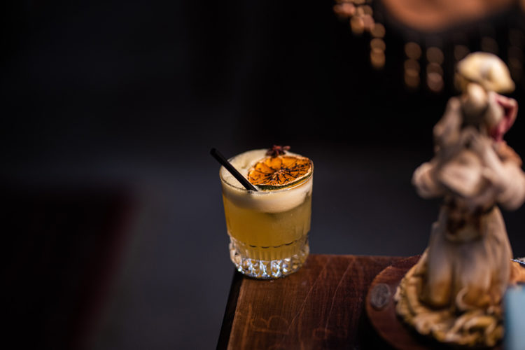 cocktail in short glass with straw and garish