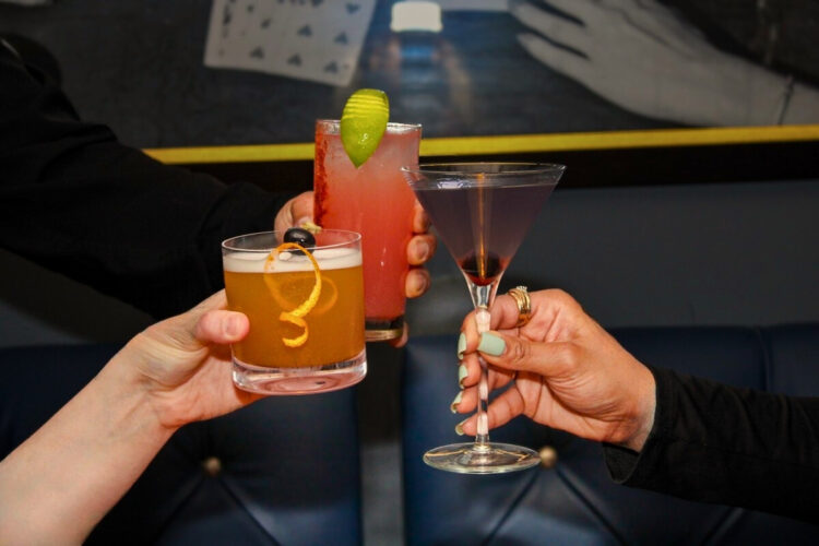 Three Friends Toasting with Cocktails at PRC Speakeasy Bar in Amarillo TX
