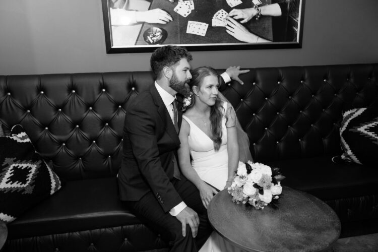Couple posing for a wedding photoshoot on a lounge sofa.