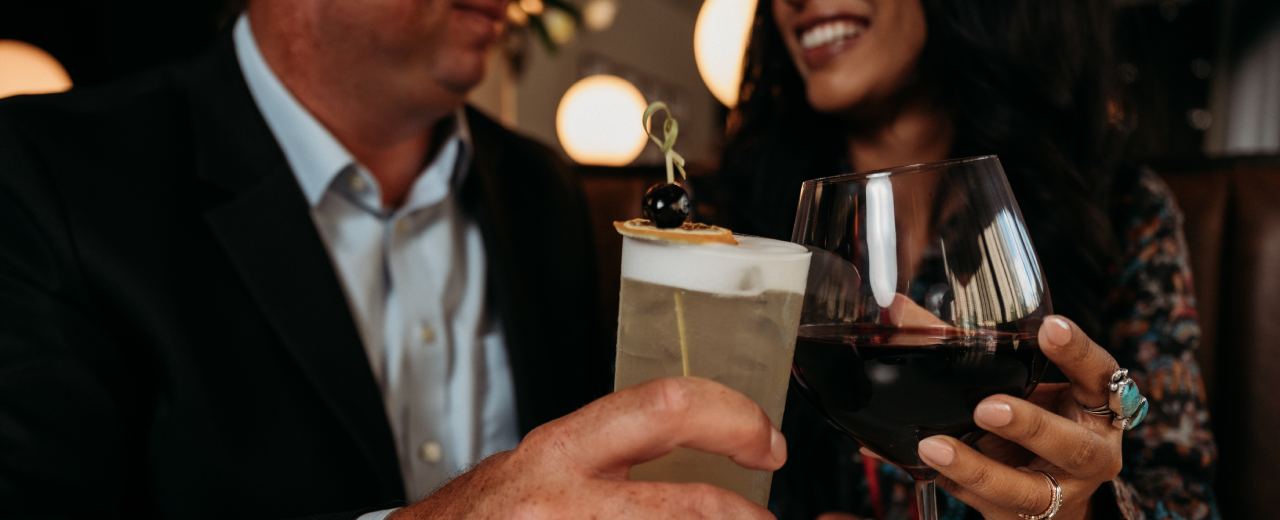 Couple toasting drinks at a restaurant.