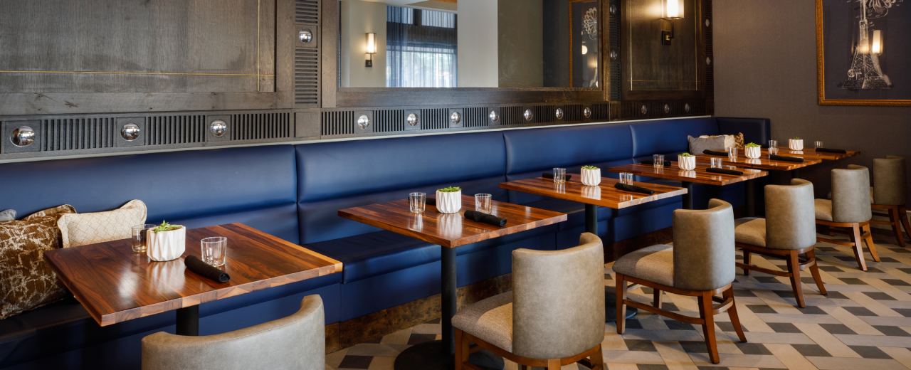 restaurant interior with blue booth seating and wooden tables
