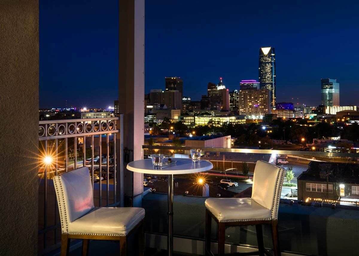 Table for two on balcony of O Bar overlooking Oklahoma City skyline at night