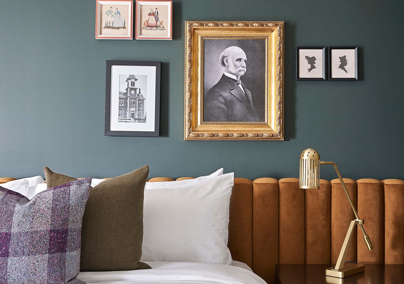 close up of hotel guest room bed with decorative pillows and artwork on wall