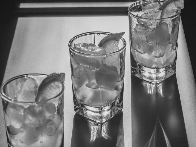 three glasses of cocktails set in a diagonal across a table