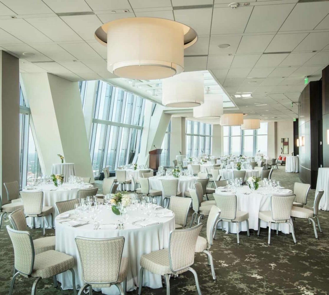 a grand meeting or event venue at Vast that is brightly lit by the large floor to ceiling windows overlooking the city skyline