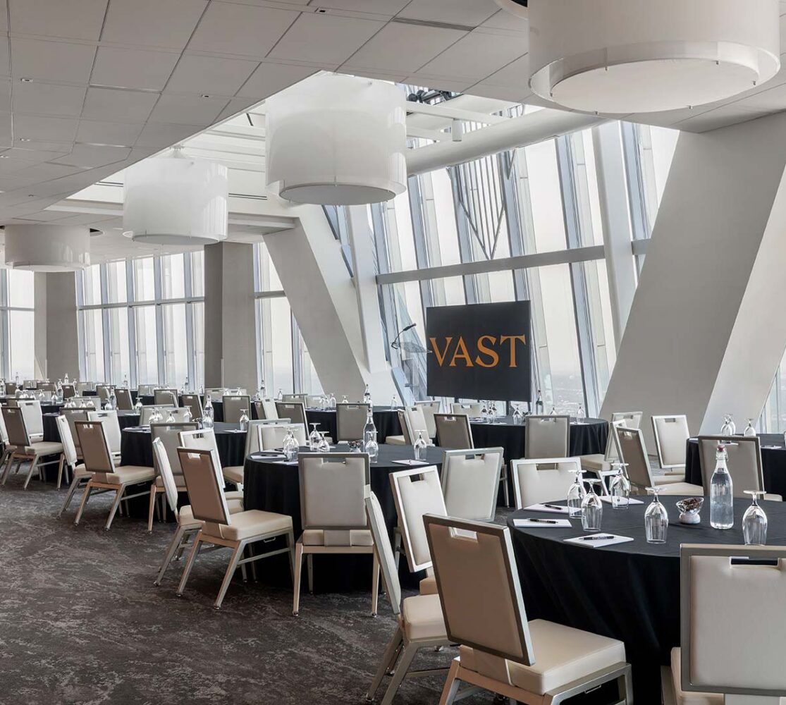 bright meeting space with floor to ceiling windows tables and chairs setup side by side