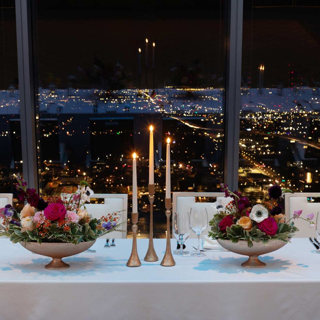 flowers and candles on set table in front of night time sky view