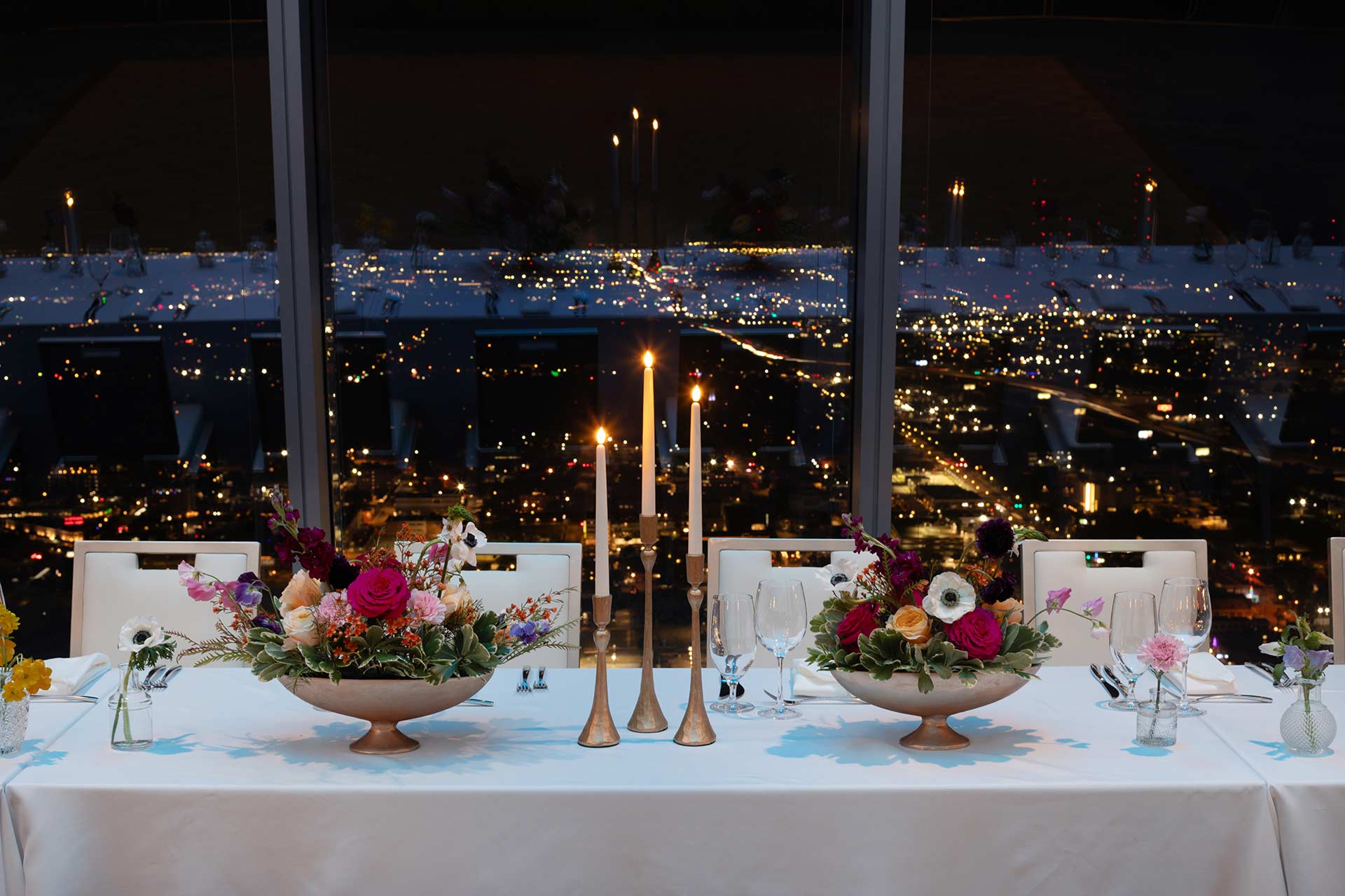 flowers and candles on set table in front of night time sky view